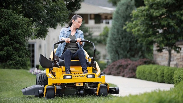 Woman riding Cub Cadet Ultima Gas Zero-Turn Mower in yard