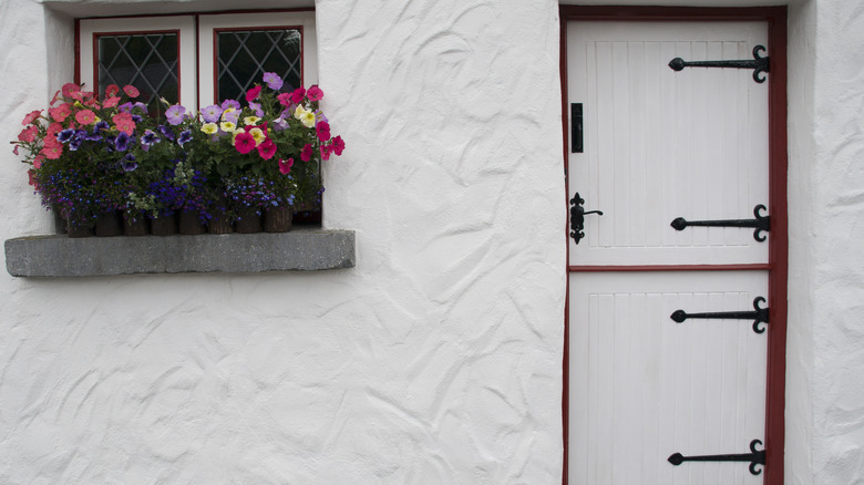 W hite Ducth door with black iron details on a white cottage in Ireland