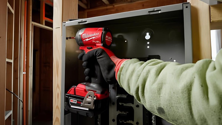 a person using the Milwaukee Hammer Drill and Impact Driver Combo Kit
