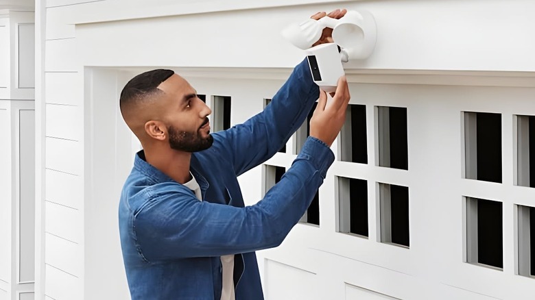 a person mounting Ring Floodlight Cam Outdoor Security Camera