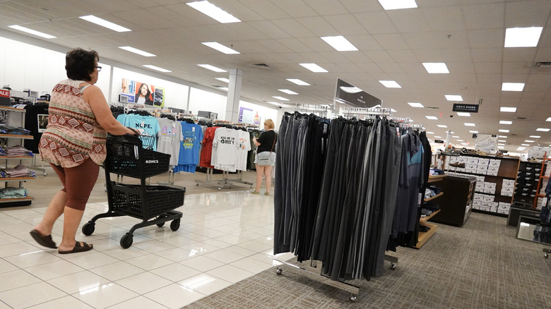 A woman pushes a cart through Kohl's