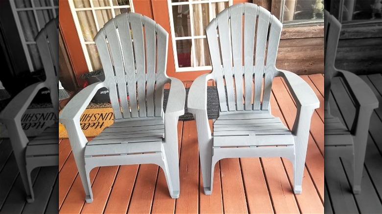 Two gray Adirondack chairs on patio decking.