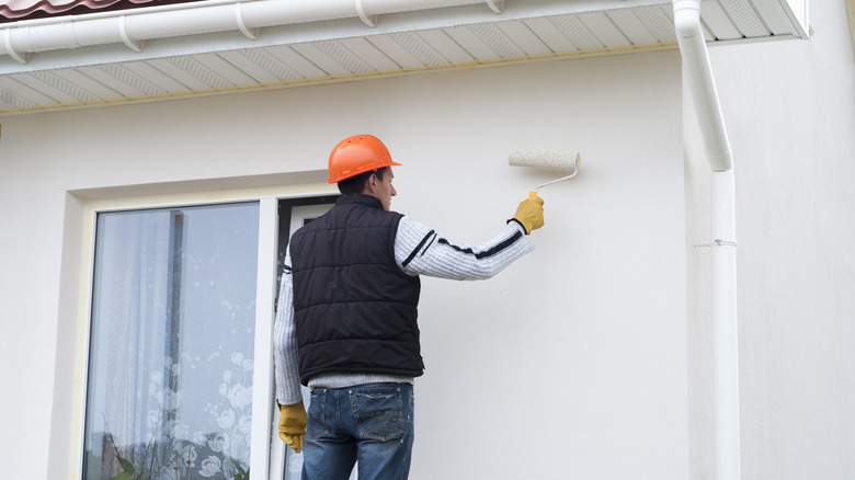 A man painting the outside of a house