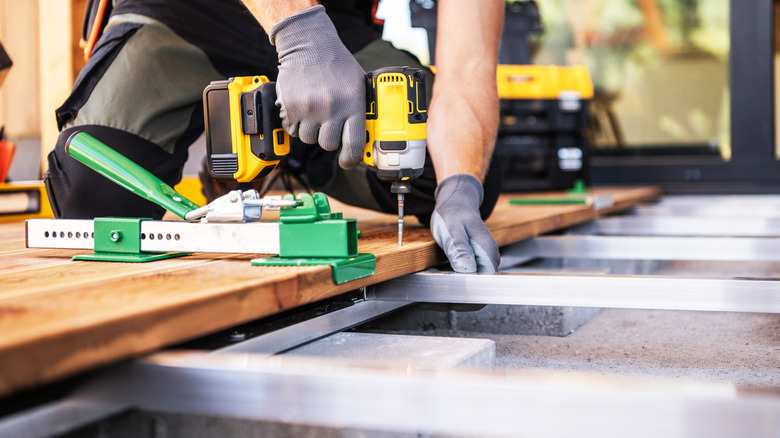 A man building a deck with power tools