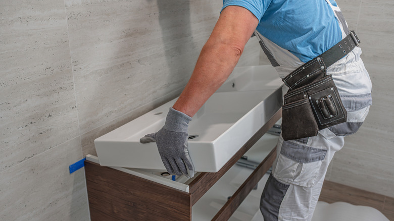 Man installing a new sink in the bathroom