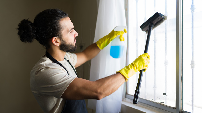 Man cleaning window with squeegee