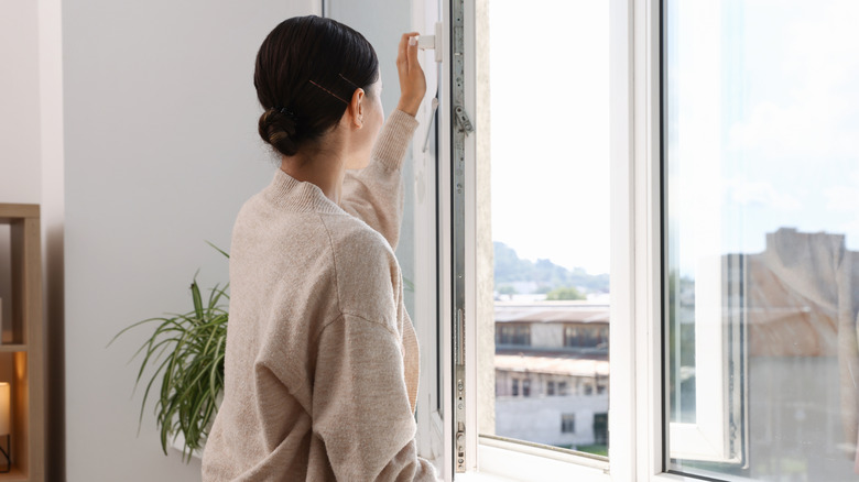 Woman opening a window