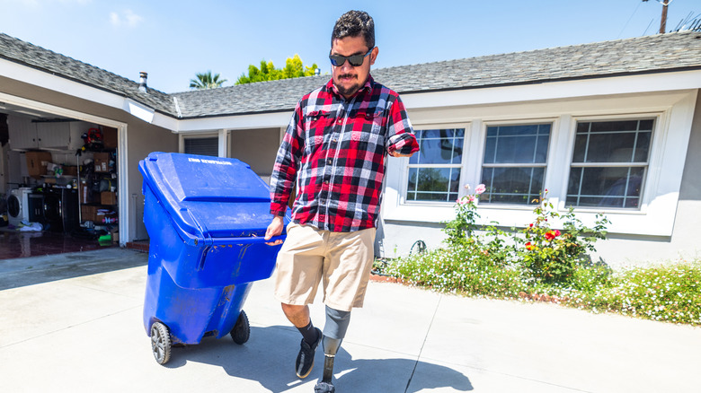 Man taking the trash to the curb