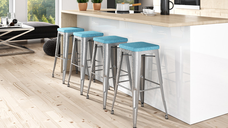 Metal framed bar stools with a blue top at an island
