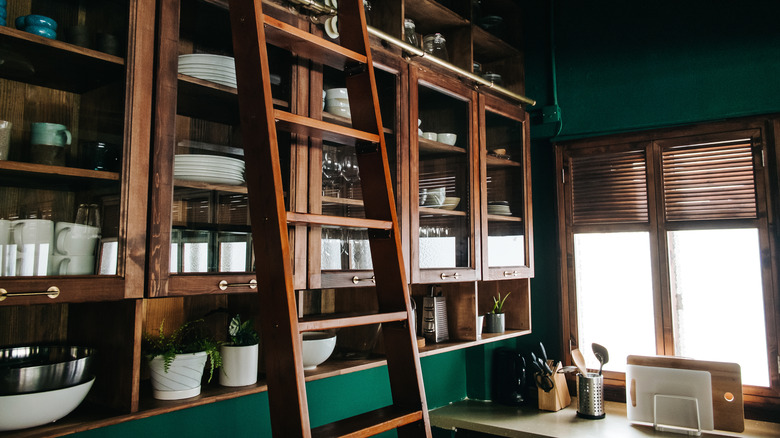 Kitchen walls painted in dark green with wood cabinets