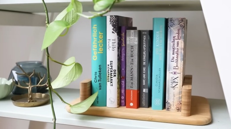 STOLTHET Cutting board holding books on shelf