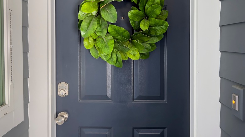 grey door with green wreath