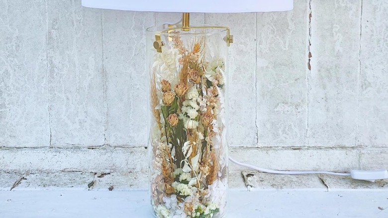 Dried flowers in a clear glass lamp base