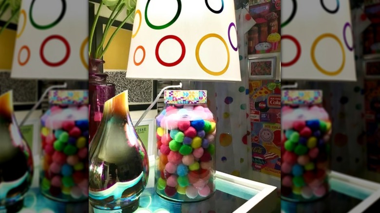 Colored pom poms in clear glass lamp base