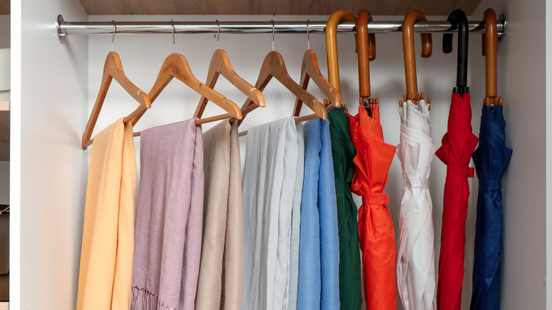 Linens and umbrellas hanging in a closet