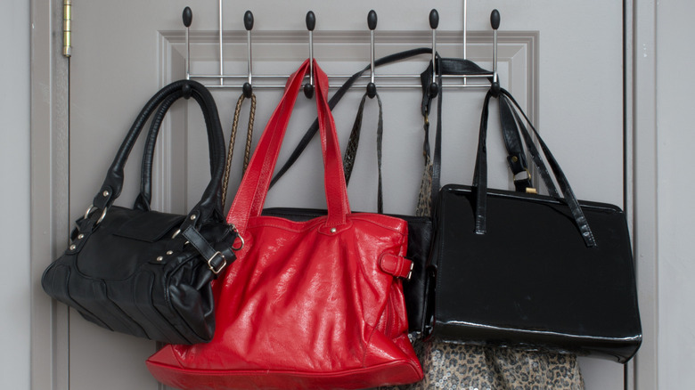 Purses hanging on a rack on a door