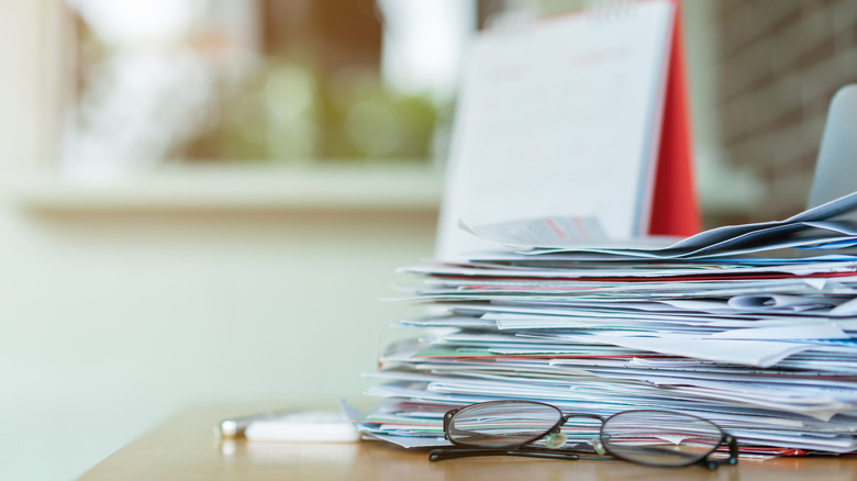 Pile of papers and glasses on counter