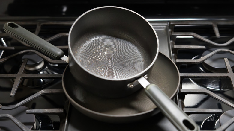 Two worn-looking nonstick pans on a stove
