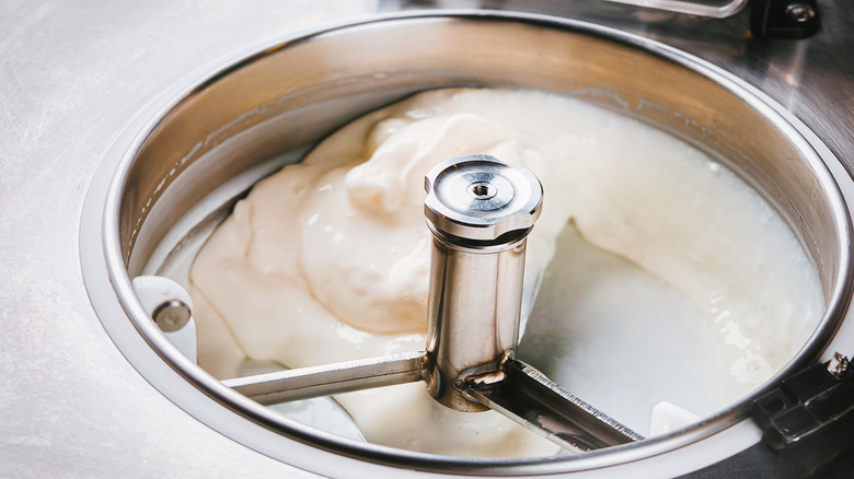 An ice cream maker stirring an ice cream that looks to be plain vanilla