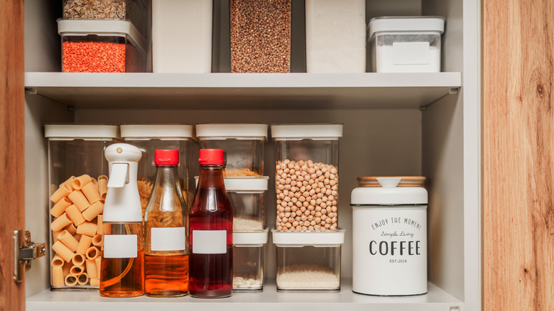 A pantry with clear plastic containers.