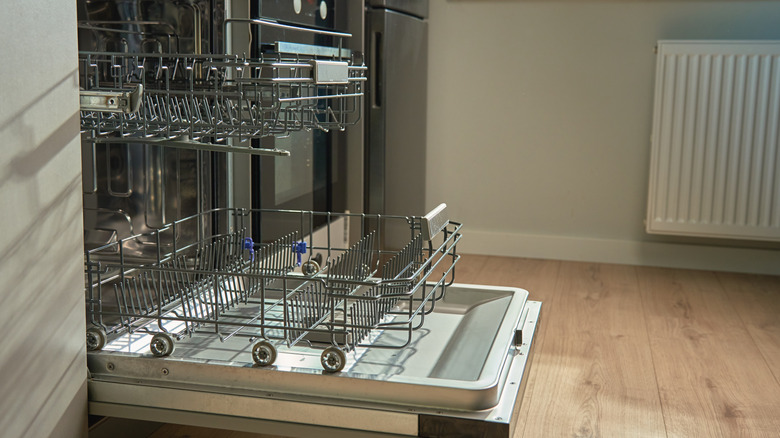 An open dishwasher in a kitchen.