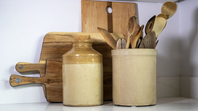 An assortment of wooden cutting boards and stoneware.