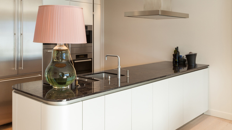 A lamp sits on top of a kitchen counter.