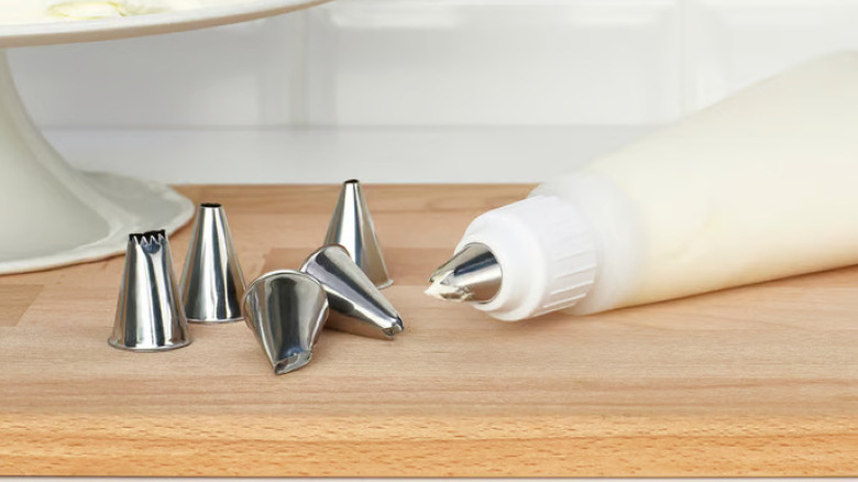 An IKEA icing bag and nozzles with leftover icing on a wood countertop