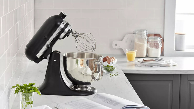 A KitchenAid stand mixer in black, on a kitchen counter