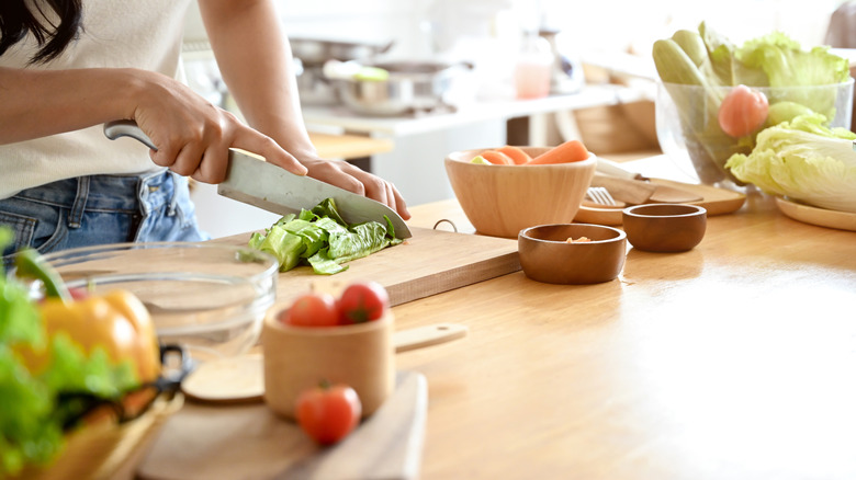 Close-up of a person chopping lettuce in their home kitchen