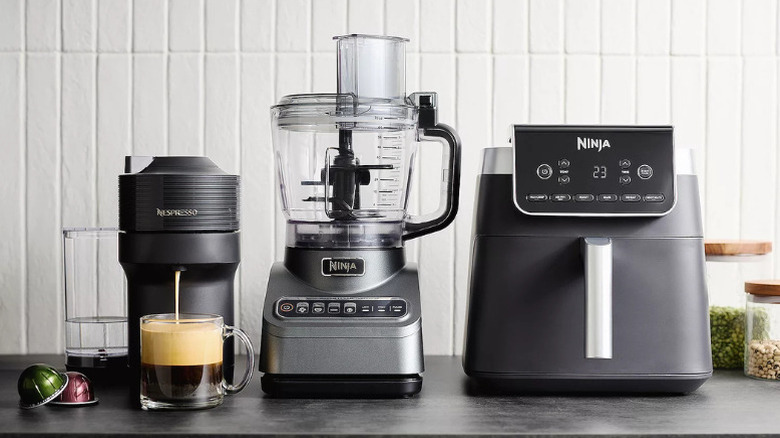 A Ninja food processor flanked by a Ninja air fryer and a Nespresso coffee machine