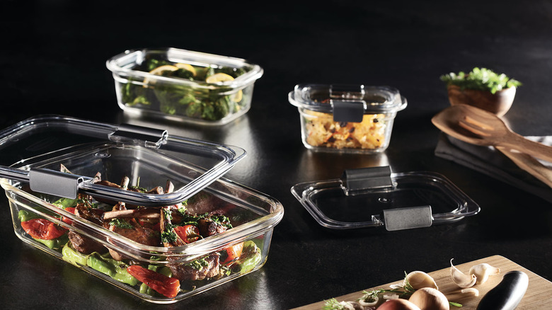 Glass food storage containers filled with food on black countertop