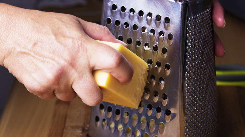 Cheese being grated with a cheese grater
