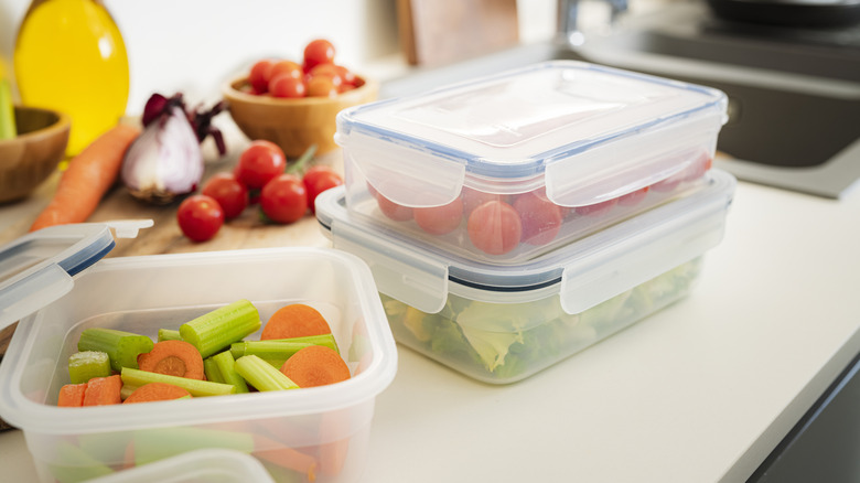 Plastic storage containers filled with vegetables on a kitchen worksurface