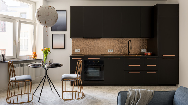 copper sink above black cabinets