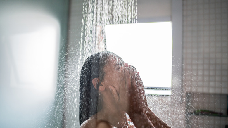 A close-up of a woman's face as she takes a shower