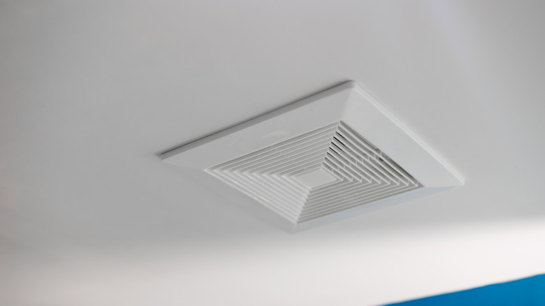 A bathroom fan on a ceiling