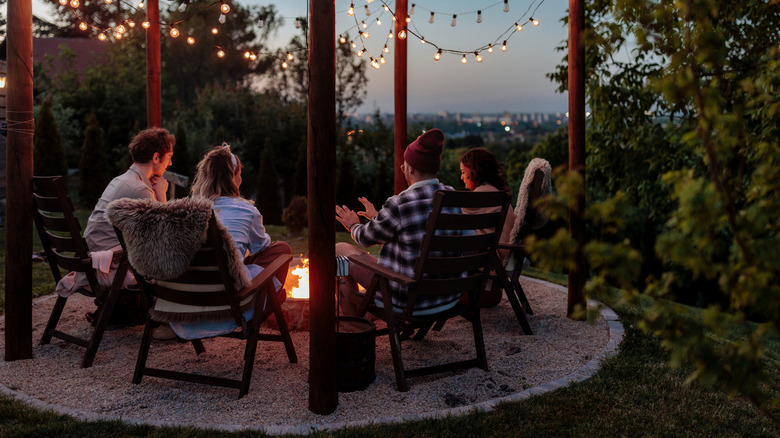 A group of people sit around a firepit