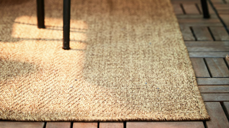 A natural woven rug under an outdoor dining table