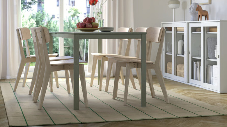 A beige and green checked rug in a dining room