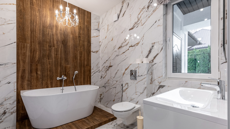 Luxe bathroom with standing bathtub and wood accent wall