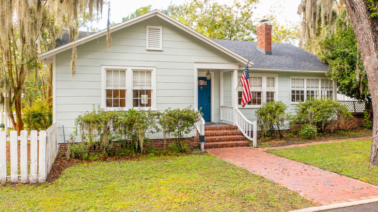 A house's front yard with sparse bushes and no flowers