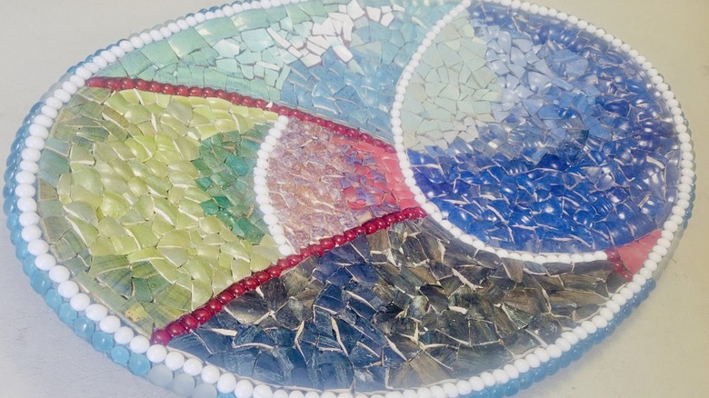 A mosaic birdbath that separates broken china by color.