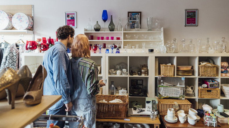couple looking at trinkets at thrift store