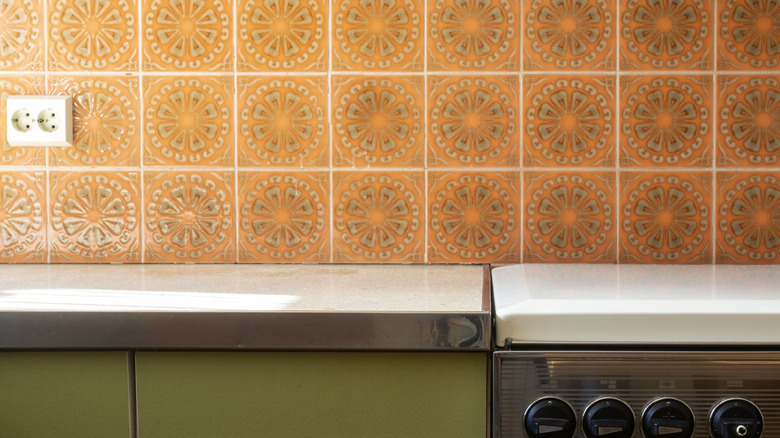 A backsplash made from dated orange tiles in a 1970s kitchen.