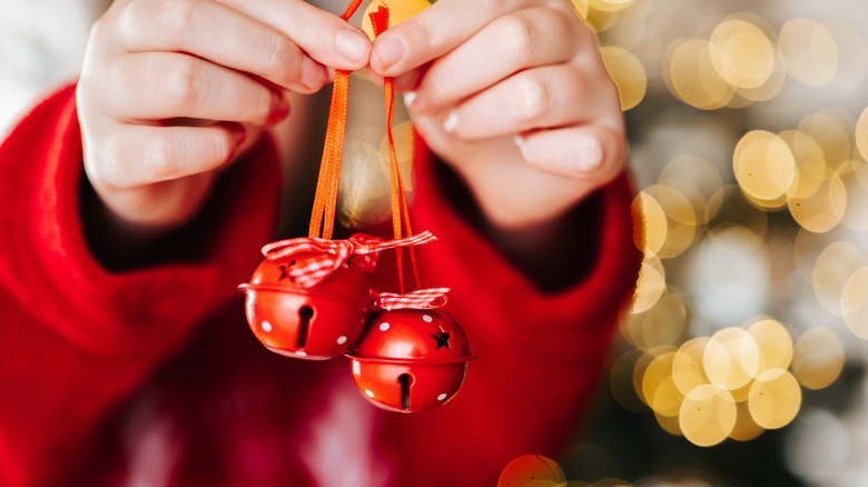 Person holding red Christmas bells