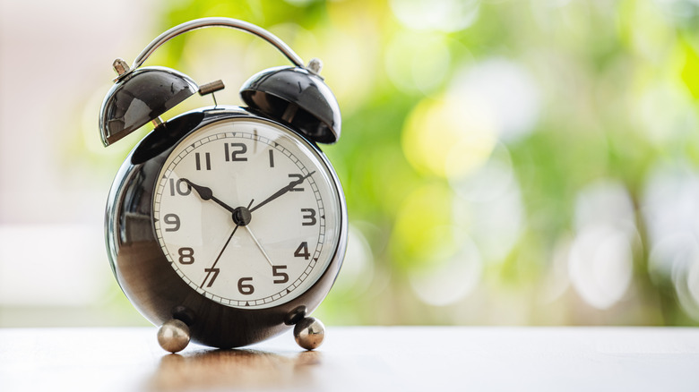 An old-school alarm clock on a windowsill