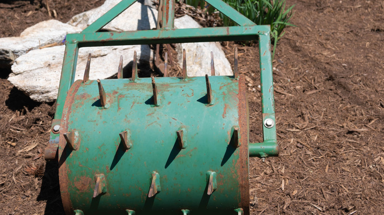 A spiked metal roller designed for aerating soil