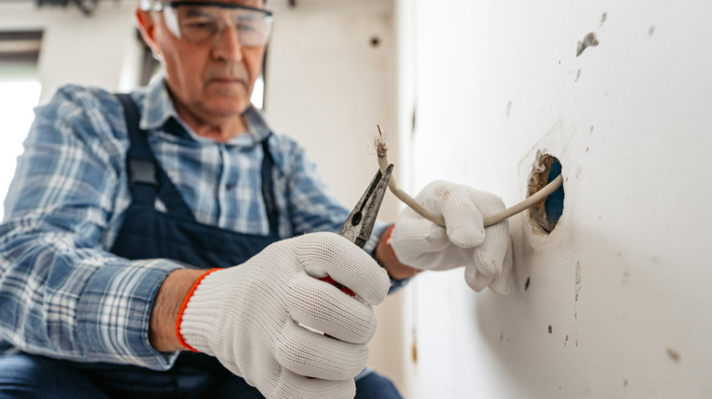 A man working with a home's electrical cables