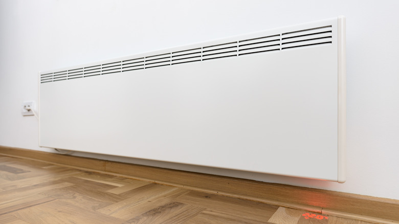 A white electric heater mounted on a wall